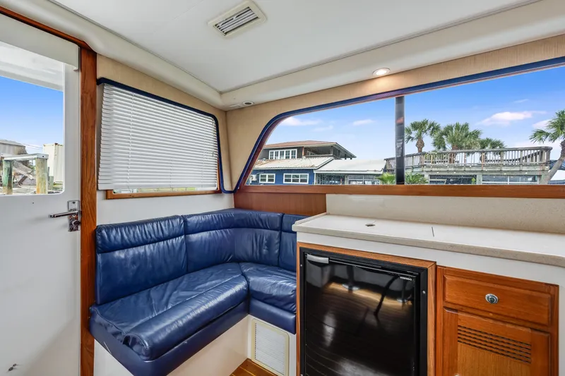 Slide: The Image of Interior of 2000 Cabo Convertible yacht with blue seating and kitchenette. - 16