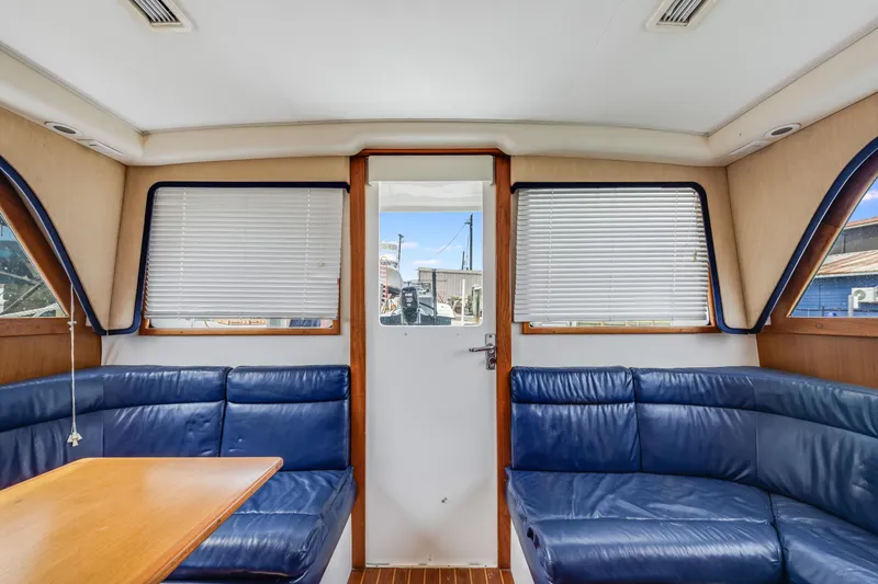 Slide: The Image of Interior of a 2000 Cabo Convertible boat with blue seating and wooden accents. - 17