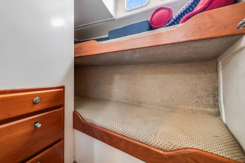 Slide: The Image of Interior of 2000 Cabo Convertible boat with cozy bunk bed and wooden cabinetry. - 23