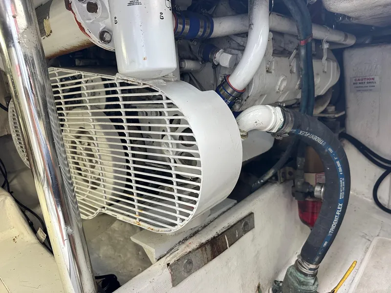 Slide: The Image of Engine compartment of a 2000 Cabo Convertible boat, featuring mechanical components and hoses. - 27