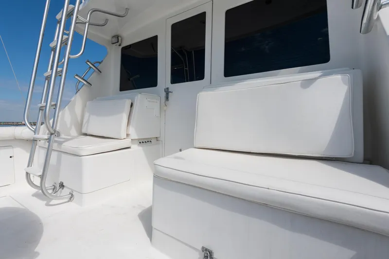 Slide: The Image of 2000 Cabo Convertible boat with white seating and ladder on deck. - 6