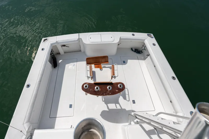 Slide: The Image of Cabo Convertible 2000 boat deck with fishing chair, surrounded by calm green water. - 7