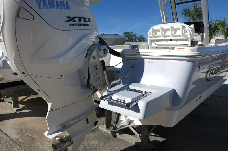Slide: The Image of 2025 Robalo 266 Cayman boat with Yamaha XTO Offshore engine, docked outdoors. - 10