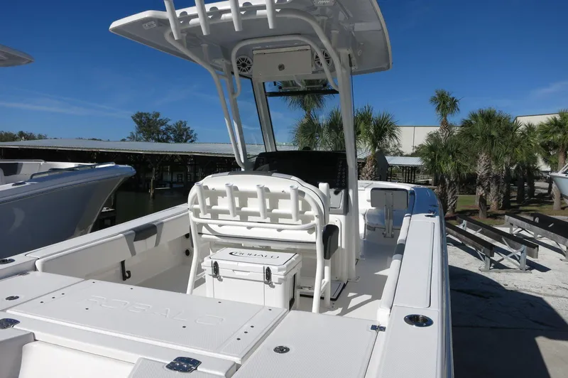 Slide: The Image of 2025 Robalo 266 Cayman boat with T-top and seating, docked under clear blue sky. - 12