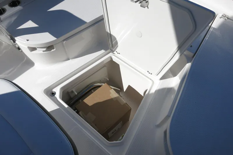 Slide: The Image of 2025 Robalo 266 Cayman boat storage compartment with open hatch and visible contents. - 22