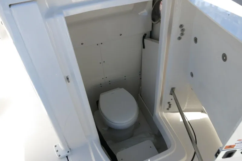 Slide: The Image of 2025 Robalo 266 Cayman boat interior with compact marine toilet. - 24