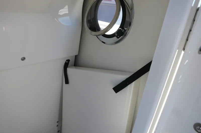 Slide: The Image of Interior view of 2025 Robalo 266 Cayman boat, featuring a porthole and storage area. - 27