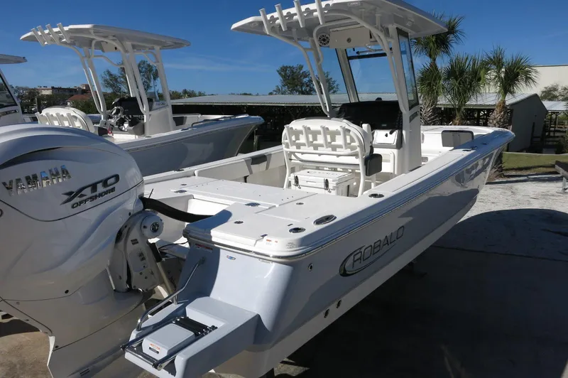 Slide: The Image of 2025 Robalo 266 Cayman boat with Yamaha engine, docked outdoors under clear blue sky. - 3