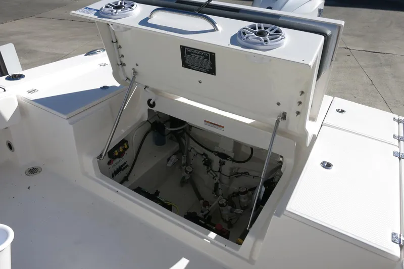 Slide: The Image of 2025 Robalo 266 Cayman boat storage compartment with open hatch and visible wiring. - 35