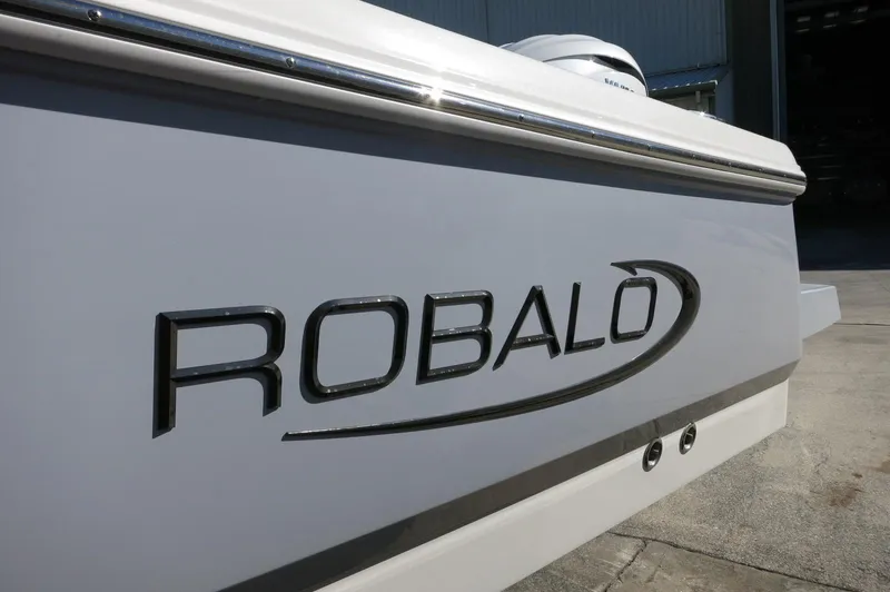 Slide: The Image of 2025 Robalo 266 Cayman boat, close-up of logo on sleek white hull. - 5