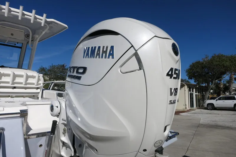 Slide: The Image of 2025 Robalo 266 Cayman with Yamaha 450 V8 outboard engine, parked outdoors. - 6