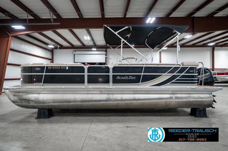 Slide: The Image of 2014 Bennington 522CR pontoon boat in a warehouse, featuring a black and silver design. - 11