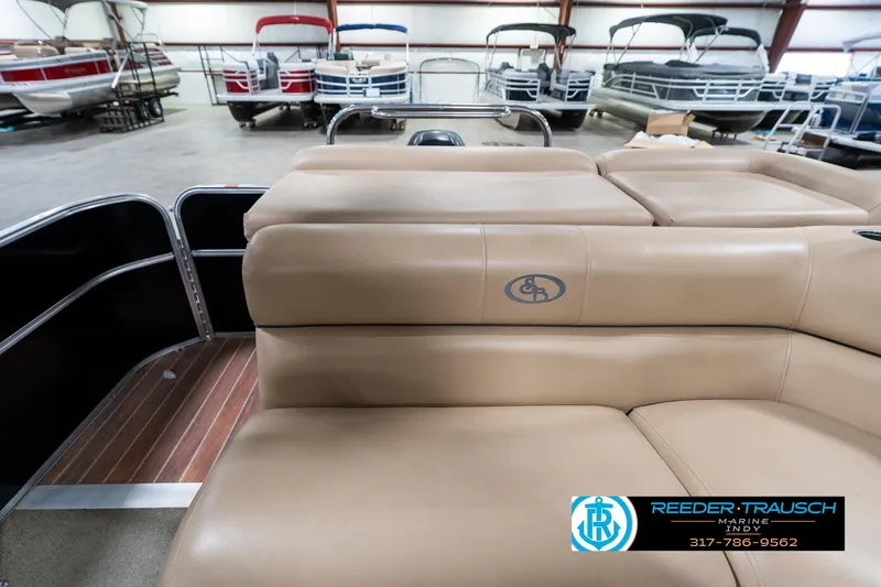 Slide: The Image of 2014 Bennington 522CR pontoon boat interior with tan seating in showroom. - 18
