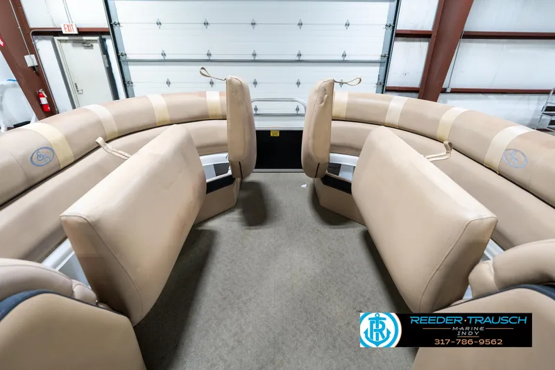Slide: The Image of 2014 Bennington 522CR boat interior with beige seating in a garage setting. - 23