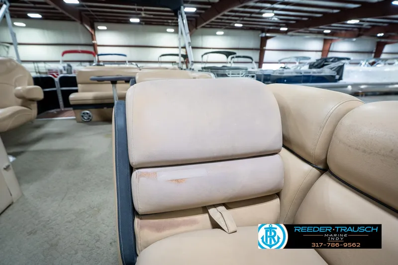 Slide: The Image of 2014 Bennington 522CR boat interior with beige seating in a showroom. - 24