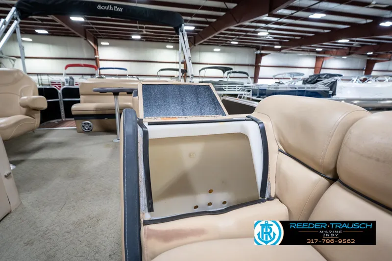 Slide: The Image of Interior of a 2014 Bennington 522CR pontoon boat with beige seating and storage compartment. - 25