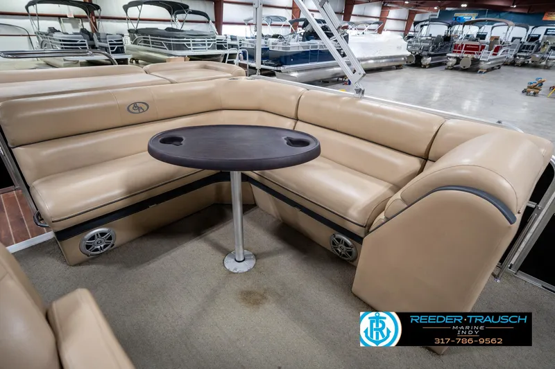 Slide: The Image of 2014 Bennington 522CR pontoon boat interior with beige seating and round table. - 26