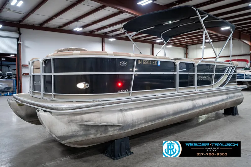 Slide: The Image of 2014 Bennington 522CR pontoon boat in indoor storage, featuring a black canopy and sleek design. - 3