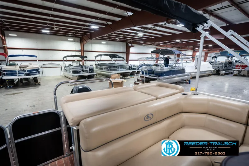 Slide: The Image of Indoor showroom with 2014 Bennington 522CR pontoon boats, featuring beige seating and various models displayed. - 30