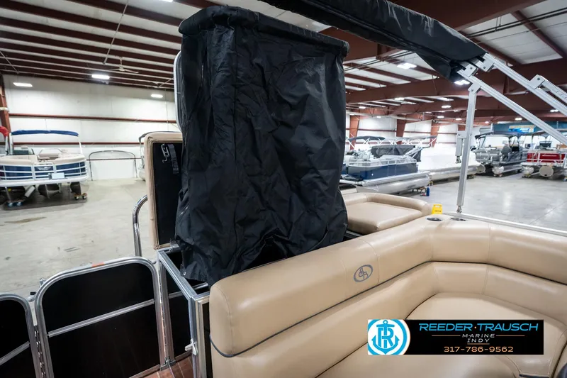 Slide: The Image of 2014 Bennington 522CR pontoon boat interior with beige seating in a showroom. - 32