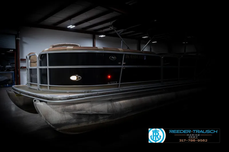 Slide: The Image of 2014 Bennington 522CR pontoon boat in a dimly lit indoor setting. - 4