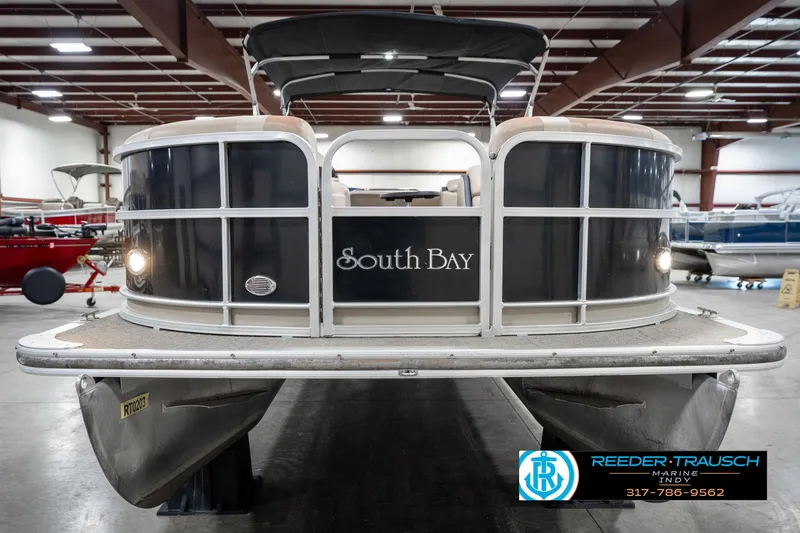 Slide: The Image of 2014 Bennington 522CR pontoon boat in showroom, front view with lights on. - 5