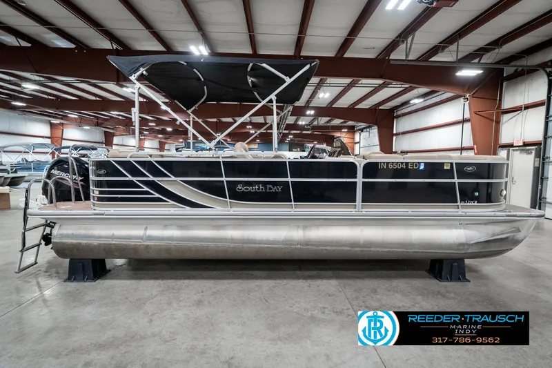 Slide: The Image of Pontoon boat in warehouse, Bennington 522CR 2014 model, black exterior, Reeder-Trausch Marine logo. - 7