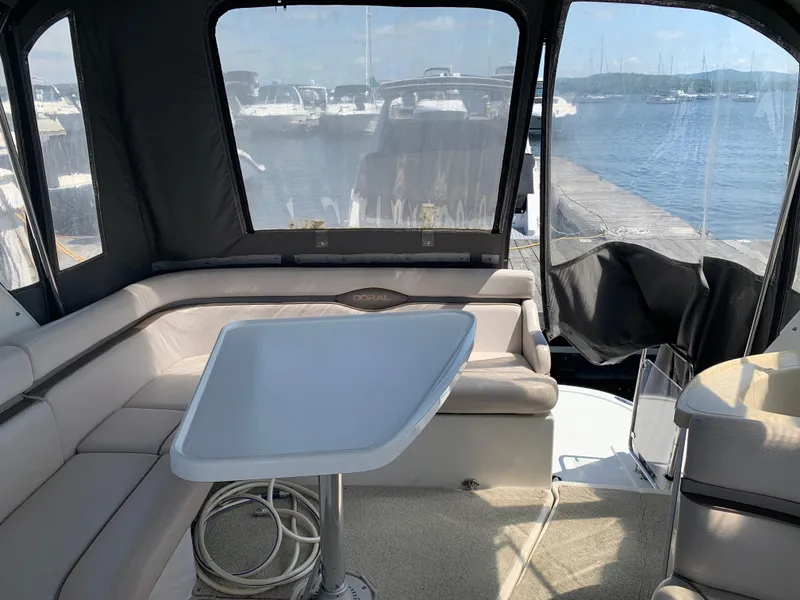Slide: The Image of 2002 Doral 310se boat interior with seating and table, docked at marina. - 12