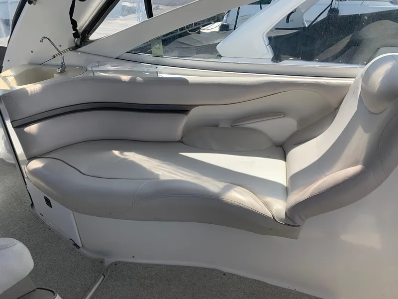 Slide: The Image of 2002 Doral 310se boat interior with curved seating and window view. - 13