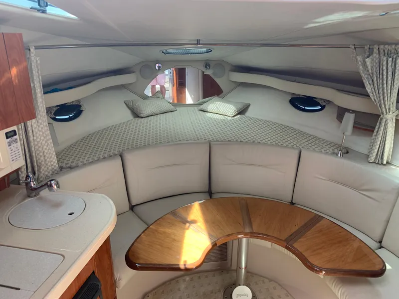 Slide: The Image of Interior of 2002 Doral 310se boat with cozy seating and compact kitchenette. - 14