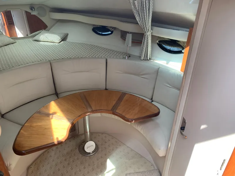 Slide: The Image of Interior of 2002 Doral 310se yacht with curved seating and wooden table. - 16