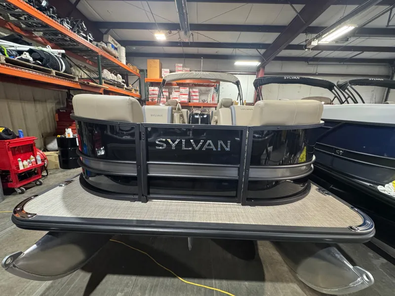 Slide: The Image of 2025 Sylvan Mirage X X3 pontoon boat in a showroom, rear view. - 1