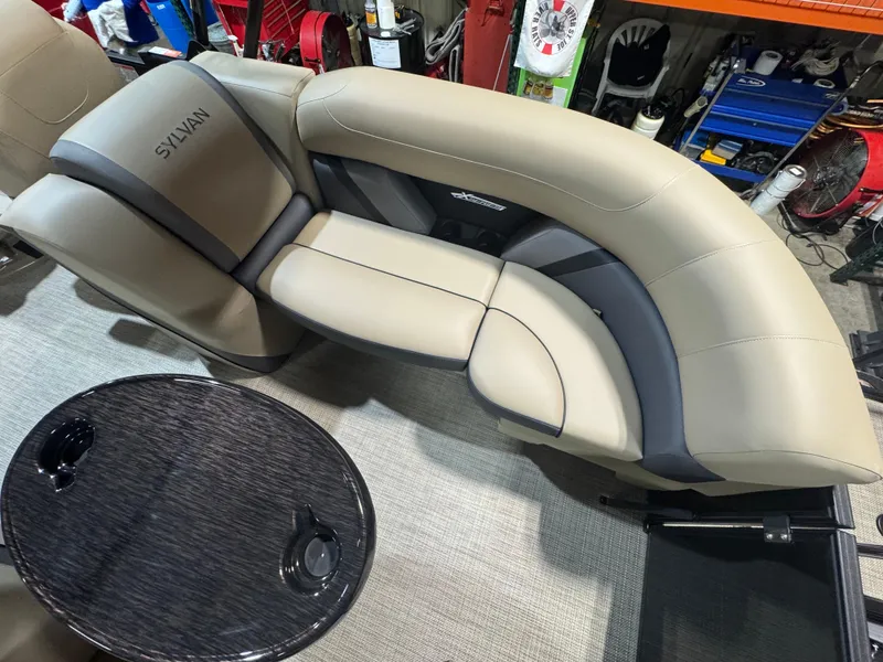 Slide: The Image of 2025 Sylvan Mirage X X3 boat interior with beige seating and round table. - 10