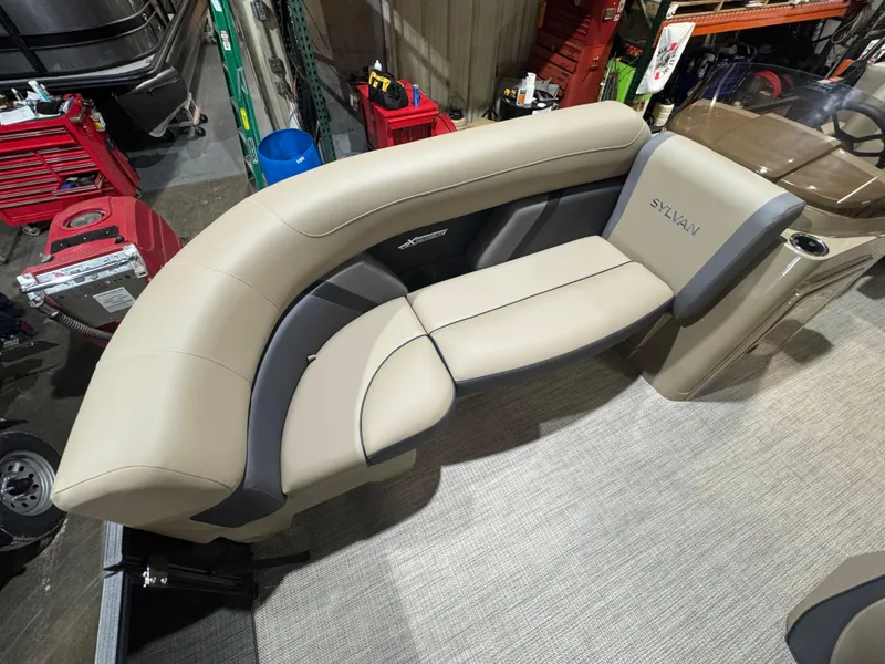 Slide: The Image of 2025 Sylvan Mirage X X3 boat interior with beige seating in a workshop setting. - 3