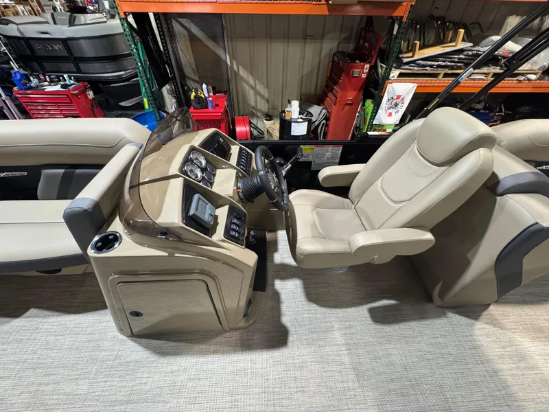 Slide: The Image of 2025 Sylvan Mirage X X3 boat interior with beige captain's chair and control panel. - 6