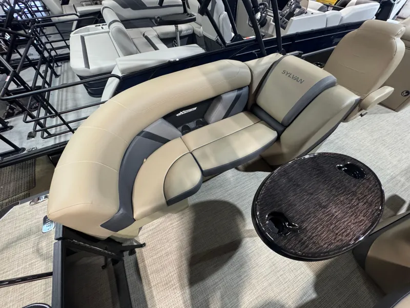 Slide: The Image of 2025 Sylvan Mirage X X3 boat interior with beige seating and a round table. - 9