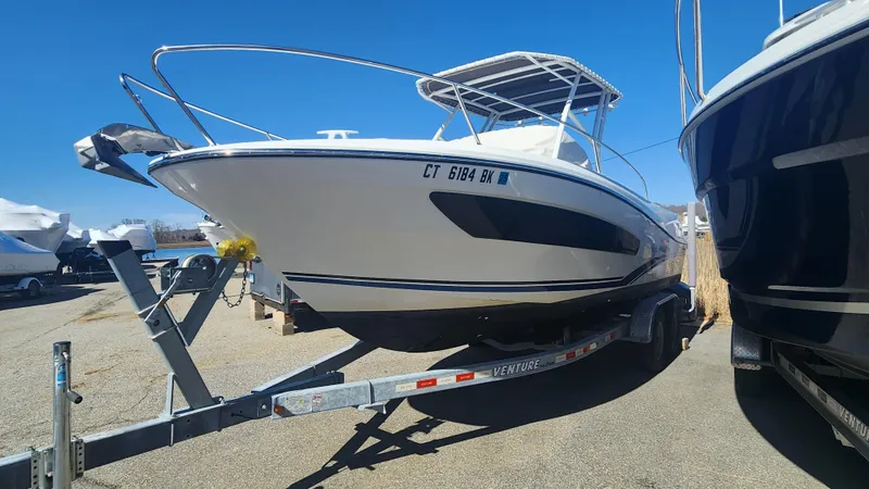 Slide: The Image of 2020 Jeanneau Leader 7.5 WA boat on trailer, parked outdoors under clear blue sky. - 13