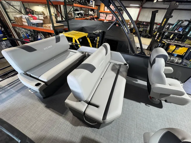Slide: The Image of 2025 Sylvan L3 DLZ pontoon boat interior with gray seating in a showroom. - 7