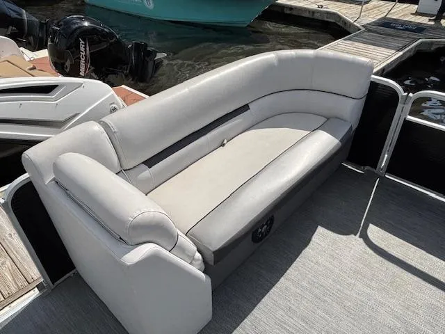 Slide: The Image of 2022 Sweetwater 2286 boat with gray seating, docked near water. - 10