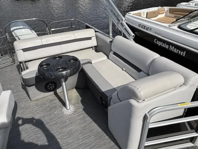 Slide: The Image of Sweetwater 2286 pontoon boat, 2022 model, featuring comfortable seating and a round table on deck. - 11