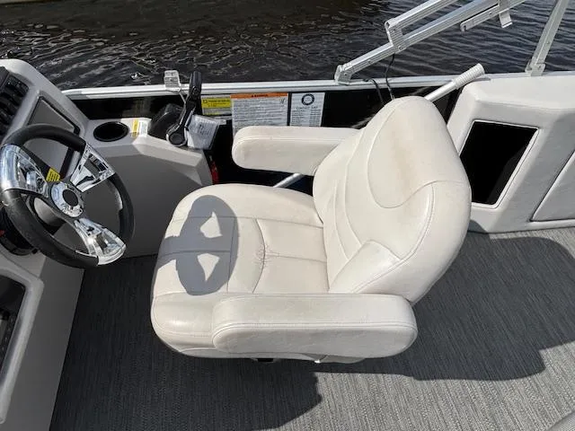 Slide: The Image of Captain's chair on 2022 Sweetwater 2286 boat, featuring a sleek steering wheel and control panel. - 13