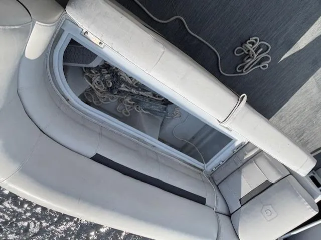 Slide: The Image of 2022 Sweetwater 2286 boat interior with open storage compartment and coiled rope. - 23