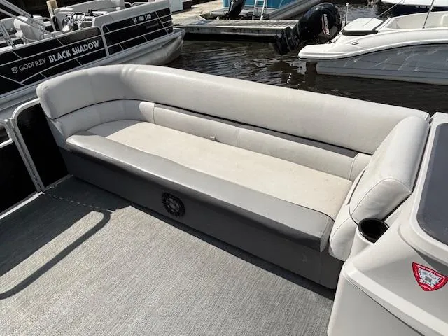 Slide: The Image of 2022 Sweetwater 2286 boat with spacious seating, docked near other boats. - 9