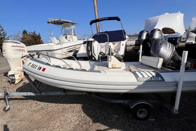 Slide: The Image of 2020 Novurania DL 400 boat on trailer, parked outdoors with other boats. - 9