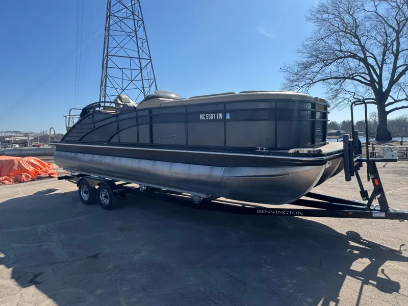 Slide: The Image of 2016 Bennington 2275 RCW pontoon boat on trailer, parked outdoors under clear sky. - 1