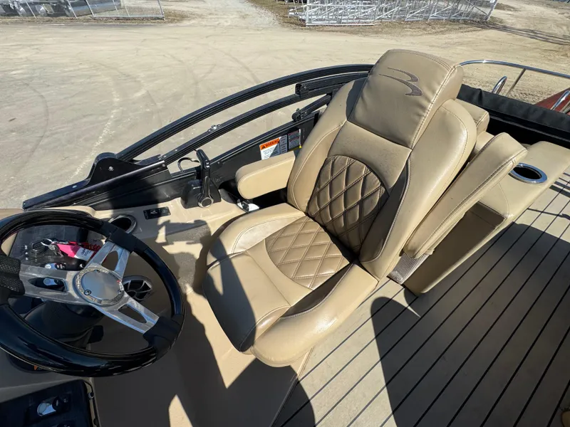 Slide: The Image of 2016 Bennington 2275 RCW boat interior with tan leather captain's chair and steering wheel. - 12