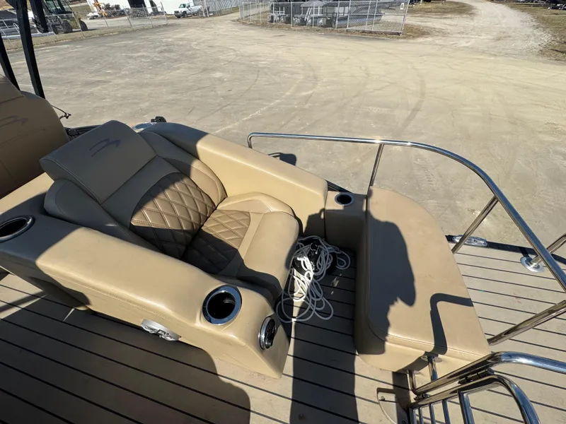 Slide: The Image of 2016 Bennington 2275 RCW boat with tan seating and cup holders on a wooden deck. - 16