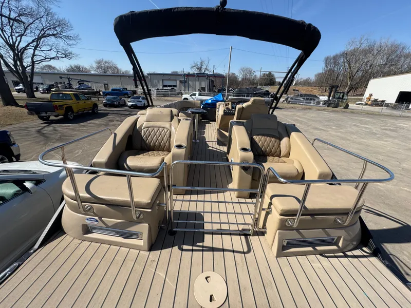 Slide: The Image of 2016 Bennington 2275 RCW pontoon boat with beige seating and canopy, parked outdoors. - 18