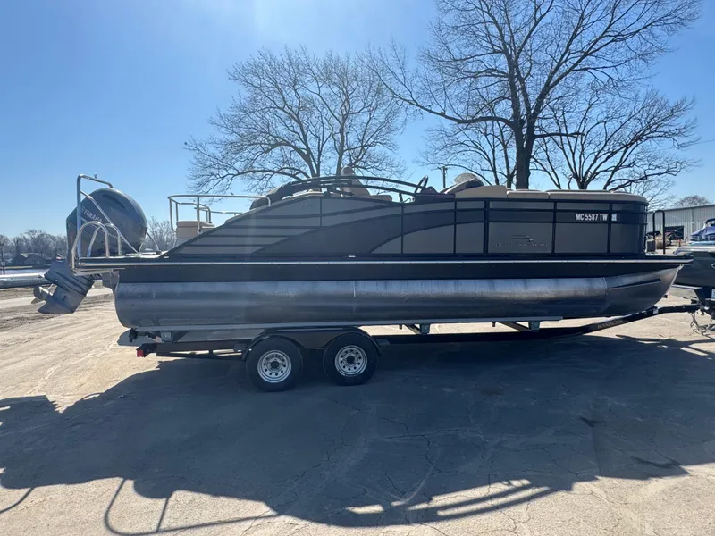 Slide: The Image of 2016 Bennington 2275 RCW pontoon boat on trailer, parked outdoors. - 2