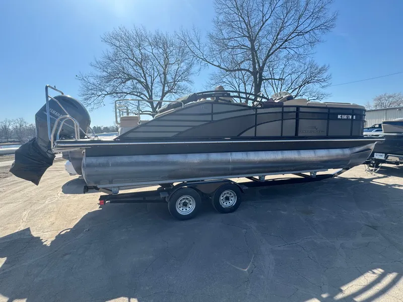 Slide: The Image of 2016 Bennington 2275 RCW pontoon boat on trailer, parked outdoors under clear sky. - 3